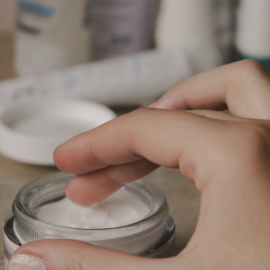 person's finger touching white cosmetic cream